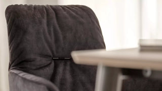 Detail van de rug van een antraciet Mobitec Aura stoel aan een tafel