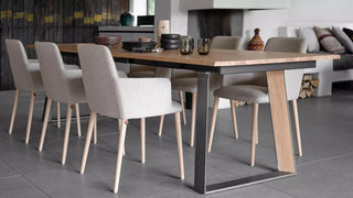 Sfeerbeeld van crème Mobitec Rob armstoelen rond een lange houten tafel in een loft