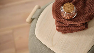 Detail of a Mobitec Thalia pouf with wooden tray, handle and glass jar