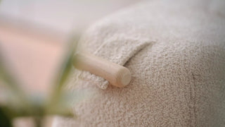 Close-up of a bouclé Mobitec Thalia pouf with wooden handle