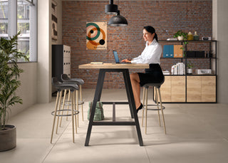 Photo d'ambiance d'une bibliothèque Buronomic Alto noir et Nebraska derrière une femme à une table haute