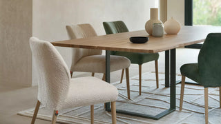 Lifestyle image of cream and green Mobitec Enora chairs at a wooden dining table
