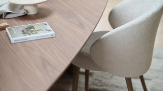 Detail van de beige kuip van de Mobitec Neo stoel aan een houten tafel