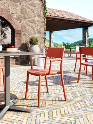 Sfeerbeeld van oranje Gaber To-Me stoelen op een terras bij een stenen gebouw